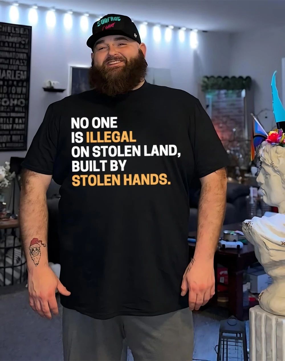 Black woman wearing no one is Illegal on stolen land built by stolen hands shirt